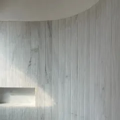 A play of materials at the House of Galleries. This fluted marble wall adds depth, texture, and character, with a built-in niche that catches the light.