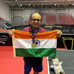 Gajanan Parmar proudly holds the Indian flag after his triumphant performance at the ITTF World Masters Championships, showcasing his gold medal.