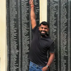 Pointing to my name on the monument at my school. A moment of immense pride and nostalgia.