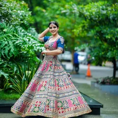 We love capturing the life and movement of a garment. Here, a model twirls in a vibrant, multi-colored ethnic lehenga, showcasing the full skirt and intricate patterns against a lush garden backdrop. This is a key shot for any Indian wear catalogue.