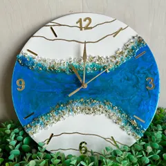 A beautiful geode-style clock with a river of blue resin and gold crystals. This design uses Arabic numerals for a modern, clean look against the white background.
