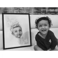 A black and white version of the baby girl with her portrait, emphasizing the likeness between the art and the adorable subject.