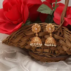 This close-up of pearl-beaded jhumkas is styled with a floral background, highlighting the delicate craftsmanship and making it ideal for social media or a lookbook.