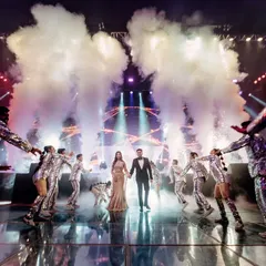 The walk-in moment. The couple emerges through a tunnel of our professional dancers and dramatic smoke effects, walking onto a reflective LED floor that adds another layer of visual grandeur to their sangeet entry.