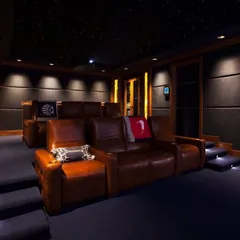 A cozy and luxurious home theater with tiered brown leather sofas. This setup is perfect for creating an intimate yet premium viewing experience, complete with a starlight ceiling and professional acoustic wall panels.