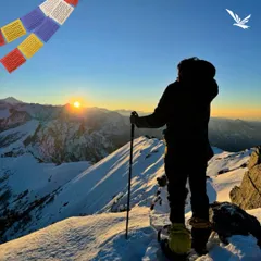 A solo trekker watching the sunrise after conquering a snowy peak. We ensure even our solo travelers feel safe and empowered to witness moments like these on our guided treks.