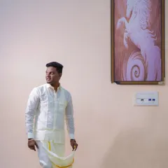 A handsome portrait of the groom in traditional South Indian attire. The simple background and natural light put the focus on his classic look.