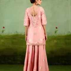 The back of this pink sharara kurta reveals intricate embroidery and a delicate tie-up detail. It’s a design that ensures you look elegant from every angle.