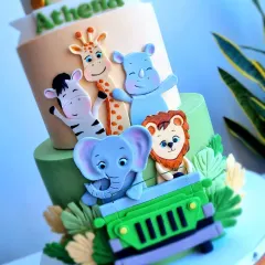 A detailed shot of the lower tier, showcasing the happy fondant animals in their safari jeep. I focus on creating cute, expressive characters that children will love.
