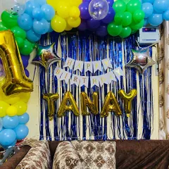 A different angle of the colorful first birthday decor, showing how the balloon arch frames the personalized backdrop.