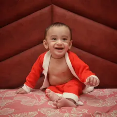 Nothing you wear is more important than your smile. This baby's joyful expression is the centerpiece of this simple and sweet indoor portrait.