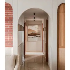 This corridor was designed as a visual journey, with arches framing the path to the bedrooms. A custom artwork at the end creates a focal point, while micro-topping textures add depth and connect the spaces.