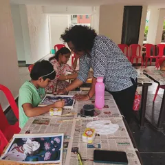 An instructor helps a young student with his Pichwai painting. We believe in nurturing creativity at every age and provide patient, step by step instruction.