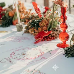 A close-up of our interactive table overlay, where guests could paint illustrations that told the couple's story. This unique detail, combined with the vibrant floral and fruit decor, made for a truly personal and engaging event.