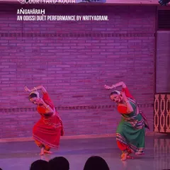 The grace of Odissi fills our stage. Here, dancers from the renowned Nrityagram perform 'Aṅgahāraḥ', a duet that showcases perfect synchronization and emotive storytelling, bringing ancient traditions to a contemporary audience in a close-up, personal setting.