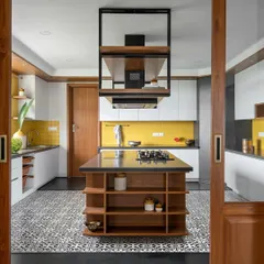The kitchen in our 'Vasudhalayah' project is a celebration of color and function. We reimagined the layout with a central island that serves as a cooking and gathering hub. The vibrant yellow piccolo tiles and patterned Moroccan flooring are balanced by clean white cabinetry and warm wood, creating a space that is both energetic and timeless.