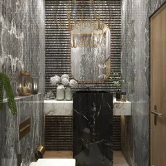 A luxurious powder bathroom featuring rich textures and deep tones. The design combines dark grey marble walls with a fluted accent panel, a freestanding black marble sink, and a unique gold chandelier.