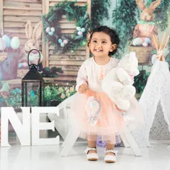 Celebrating turning one with a simple, elegant setup. The 'ONE' letters and her pretty dress are all that's needed for a beautiful milestone photo.