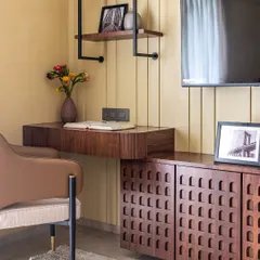 This study area is a perfect blend of form and function. A floating wooden desk is paired with a stylish armchair, while open shelving and a textured cabinet provide plenty of storage.