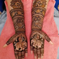 This design is a celebration of royal motifs, with majestic elephants on the palms and elegant peacocks on the arms, creating a grand and traditional bridal look.