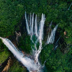 The unique, hand-shaped formation of a waterfall system in Meghalaya. This drone perspective reveals patterns you can't see from the ground.