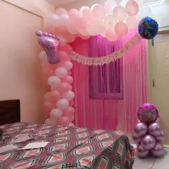 A sweet and simple "Welcome Home" decoration for a newborn baby girl. I transformed this bedroom with a pink and white balloon arch and a foil curtain backdrop to create a cozy and celebratory space.