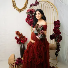 A beautiful smile from the mother-to-be, holding a bouquet that complements her flowing red gown. This is a classic portrait from my glamorous floral sessions.