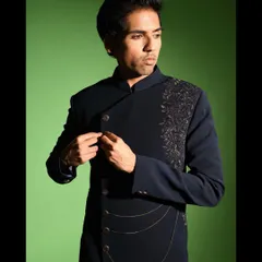 This shot shows the jacket in motion, highlighting the mandarin collar and the elegant drape of the fabric. The subtle chain detail adds a modern metallic accent to the deep navy blue.