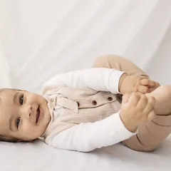 Happy feet! This playful pose, with the baby grabbing his toes, is a classic for a six-month session and always brings a smile.