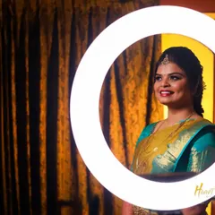 A creative bridal portrait using a ring light to frame her smiling face. This modern technique adds a unique and stylish touch.
