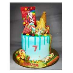 A Candyland dream cake for a 7th birthday. This chocolate truffle cake is loaded with real Skittles, lollipops, and an ice cream cone for a super sweet celebration.