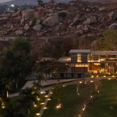 This wide evening shot shows the entire project settled into the rocky hillside. Our landscape lighting strategy focuses on accentuating the natural topography and pathways, creating a harmonious and functional nighttime environment.