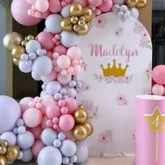 A royal celebration for a little princess. This setup features a beautiful organic balloon arch in pastel pink, lilac, and chrome gold, framing a custom backdrop with a crown motif for a fourth birthday party.