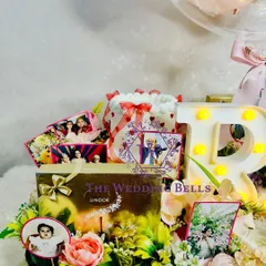 This grand birthday hamper features a light-up initial, a box of Lindor chocolates, and a beautiful arrangement of photos and flowers.
