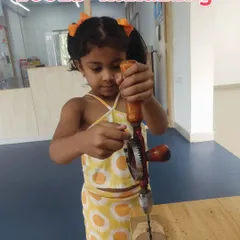 Even the youngest engineers can learn to use tools safely. This student is using a hand drill, developing motor skills and an understanding of mechanical work.