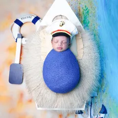 An overhead view of the nautical theme, with the baby dressed as a little captain in a boat, complete with a lifebuoy and anchor props.