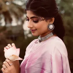 A soft, romantic look in a light pink tissue saree. Paired with oxidized silver jewelry, this portrait captures a vintage feel, perfect for a monsoon-themed shoot.