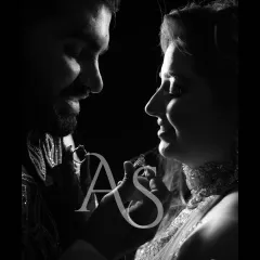 A dramatic black and white close up of the couple exchanging rings. This artistic shot focuses on the symbol of their union and the intimacy of the moment.