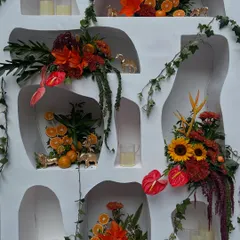 A detailed look at the custom-built wall with niches, each styled with unique floral arrangements, citrus fruits, and golden animal figures.