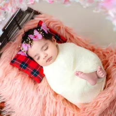 The peaceful, angelic sleep of a newborn baby, swaddled snugly and adorned with a delicate butterfly headband. I handle these precious first-day shoots with the utmost care and gentleness.