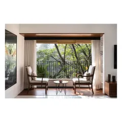 We create intimate moments within a home, like this quiet seating area for two. By perfectly framing the lush greenery outside, we turn a simple window into a private retreat, blending the interior with nature.