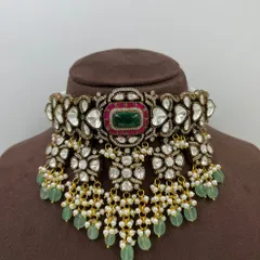 This is a prime example of our grand bridal choker collection. The piece features intricate work with high-quality Kundan, a central emerald-green stone, and delicate pearl and bead droppings, designed to be a showstopper.