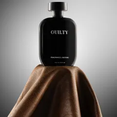 A bold, minimalist shot of a black perfume bottle on a piece of brown fabric. The simple, strong composition and lighting convey a sense of masculine sophistication and quiet confidence.