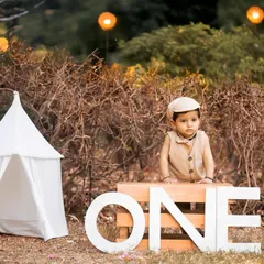 Celebrating the big 'ONE' outdoors is always special. I use natural light and rustic props like this teepee and 'ONE' sign to create a beautiful setting for your child's first birthday photoshoot in one of Jaipur's lovely parks.
