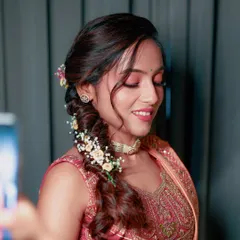 A close-up of the bride's Haldi makeup, featuring soft pink eyeshadow and a beautiful, intricate floral braid.