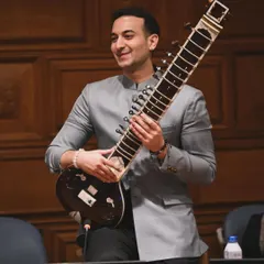 At the United Nations, holding my sitar after advocating for mental health. I am available for speaking engagements and performances at global forums and conferences.