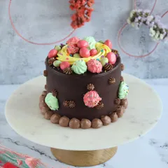 A special Easter mini cake, decorated with colorful meringues and candy eggs. It's a rich chocolate cake perfect for a small family celebration.