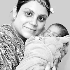 A proud mother holding her newborn close. This beautiful black and white portrait emphasizes the emotion and connection in this special moment.