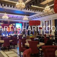 A wide view of the venue for an Avengers-themed party, showing the main stage on large LED screens and themed table settings.