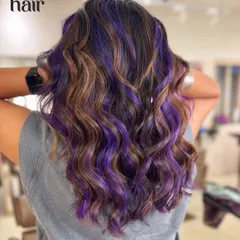 It's giving toffee crunch with a hint of blackcurrant cream. We combined a warm brown balayage with pops of vivid purple for a unique and delicious-looking colour combo.